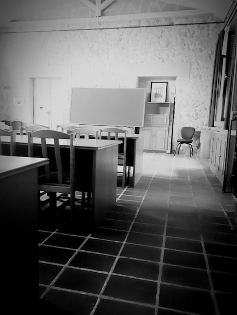 A faded and outdated classroom with limited resources, contrasting sharply with modern educational facilities. The image highlights the disparities in resources available to students in underserved communities.