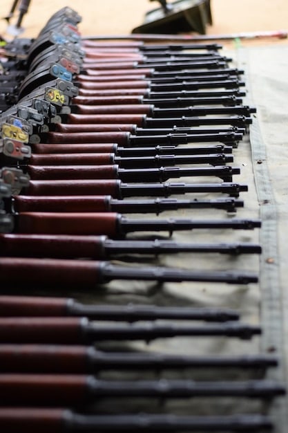A collection of various types of firearms displayed on a table, including handguns, rifles, and shotguns. This highlights the widespread availability of different kinds of weapons in America.