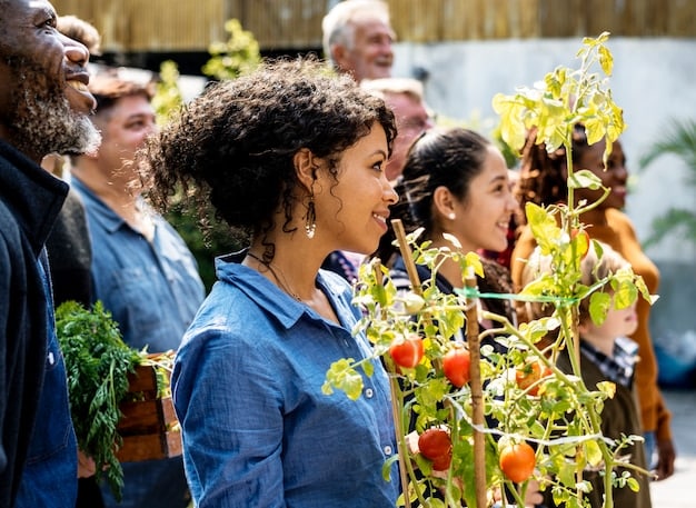 A community garden with diverse vegetables and herbs being tended by a group of people from different backgrounds. The garden is located in an urban setting, with apartment buildings visible in the background.