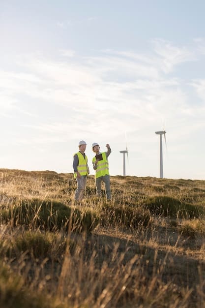 A group of engineers inspecting a wind turbine at a wind farm. The sky is clear and blue, and the turbines are spinning, generating clean energy.