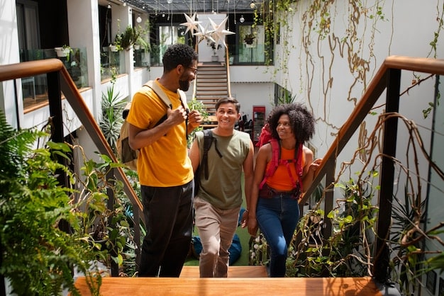 A diverse group of people from different backgrounds interacting positively in a modern, inclusive community space, with accessible ramps and green areas.